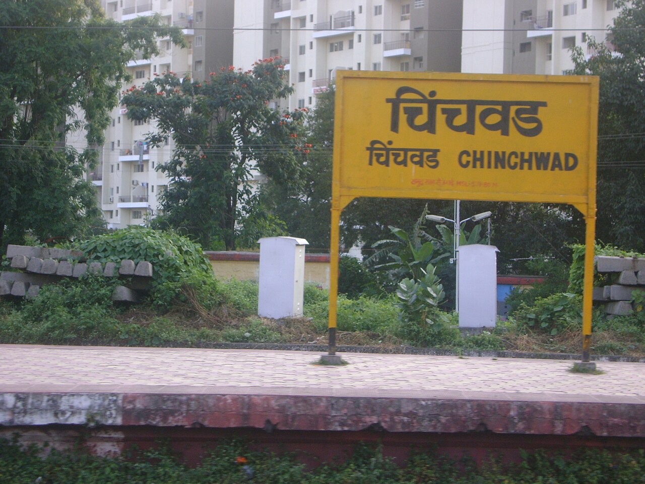 The yellow Chinchwad station board in Marathi and English on the platform
