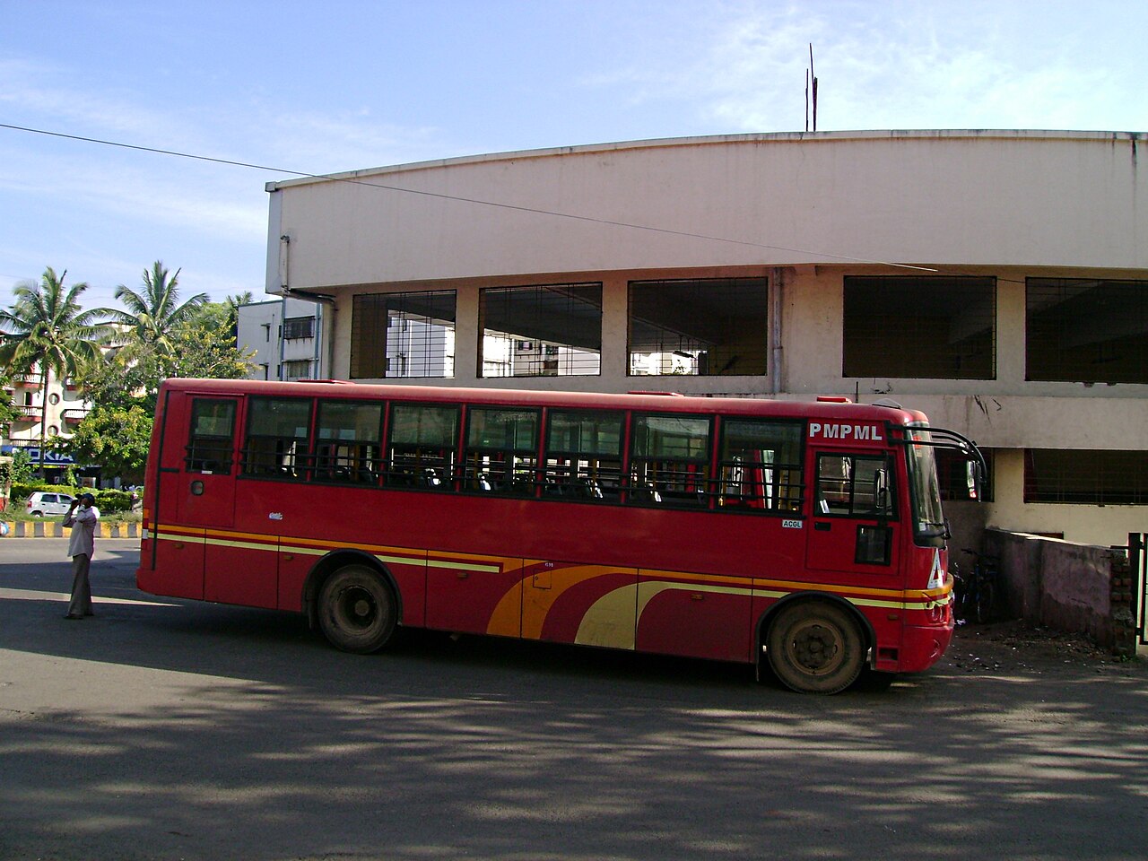 A red PMPML bus waiting at the Kothrud bus stand